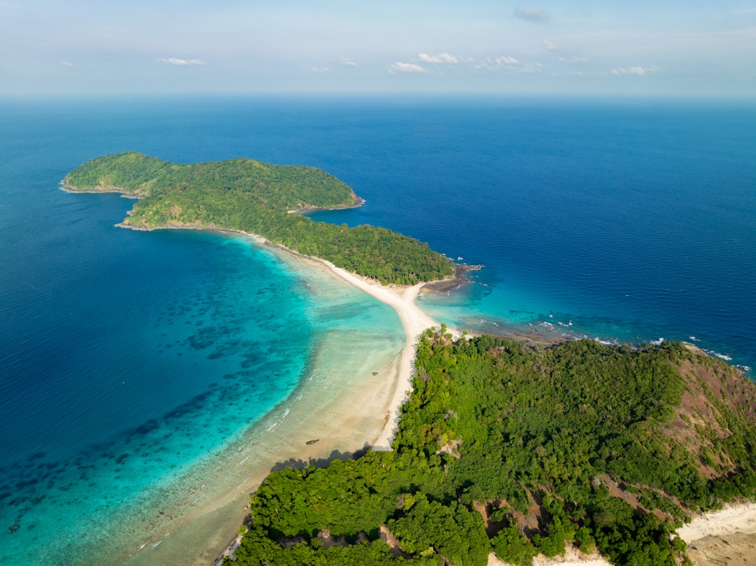Tropical island with a white sandbar and turquoise ocean. Photo by Nabil Naidu on Unsplash.